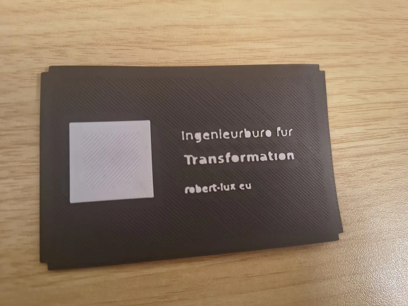 Misslungene 3D-gedruckte Visitenkarte mit unlesbarem QR-Code und unscharfer Schrift